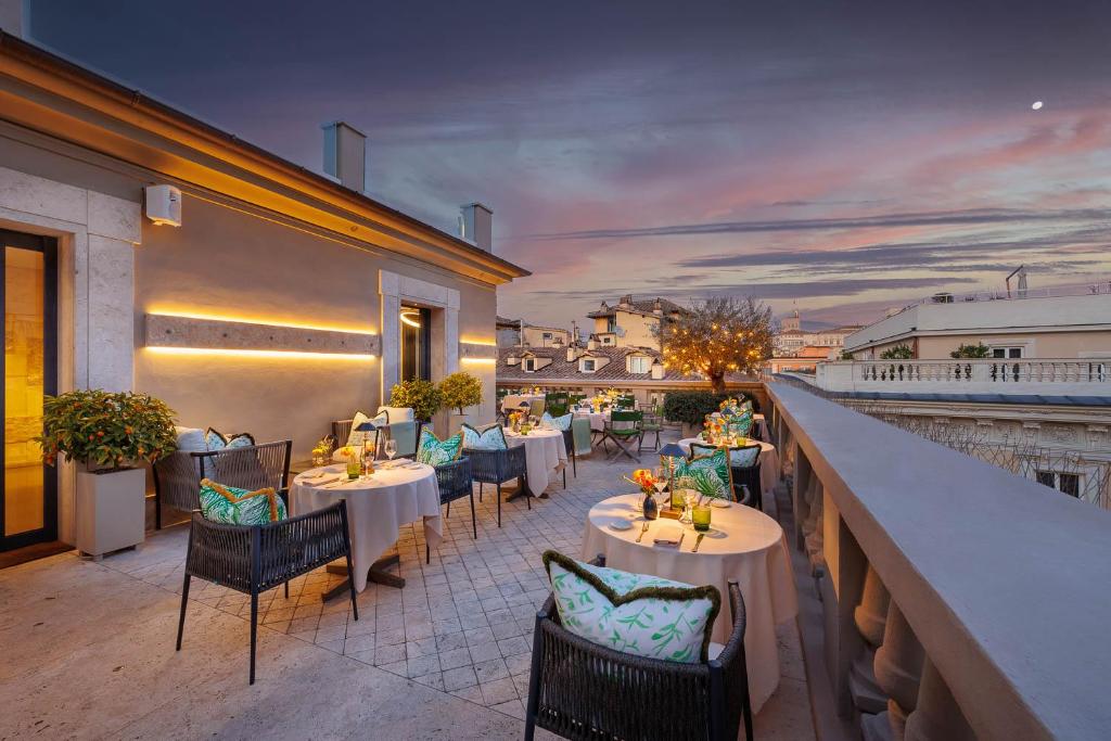 un restaurante con mesas y sillas en un balcón en Singer Palace Hotel, en Roma