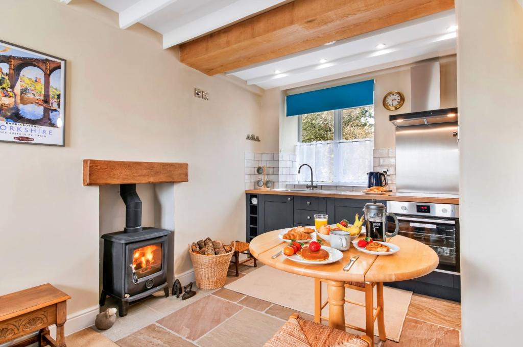a kitchen with a table and a wood stove at Finest Retreats - Tyg Cottage in Ripon