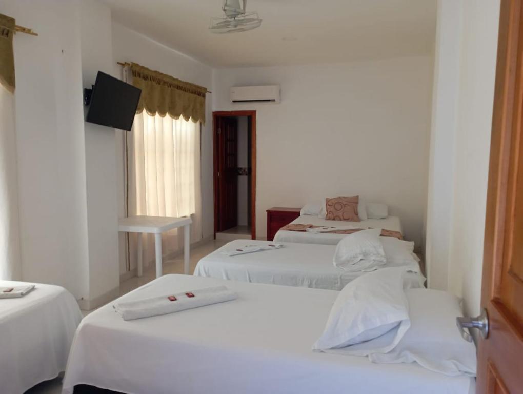 een kamer met 3 bedden en een flatscreen-tv bij HOTEL COSTA DEL SOL mav in Turbo