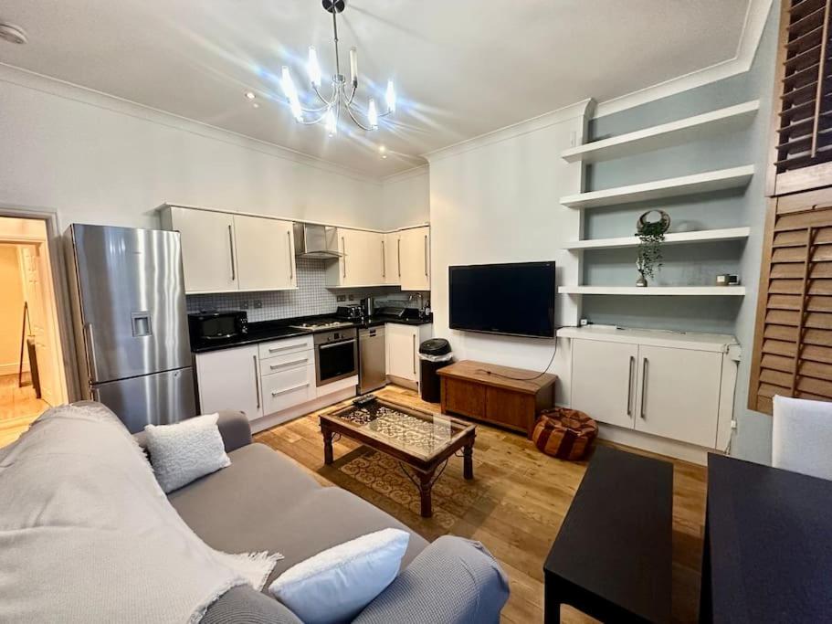 sala de estar con sofá y cocina en Spacious 2 bedroom apartment, en Londres