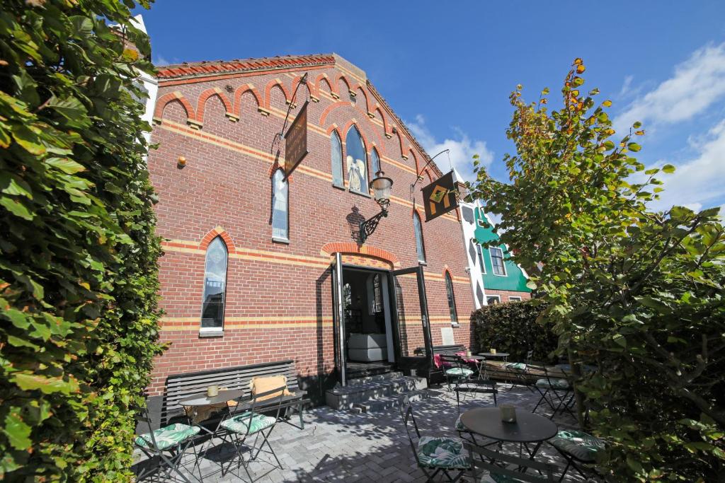 a brick building with tables and chairs in front of it at Valerius Boutique Hotel in Wormer