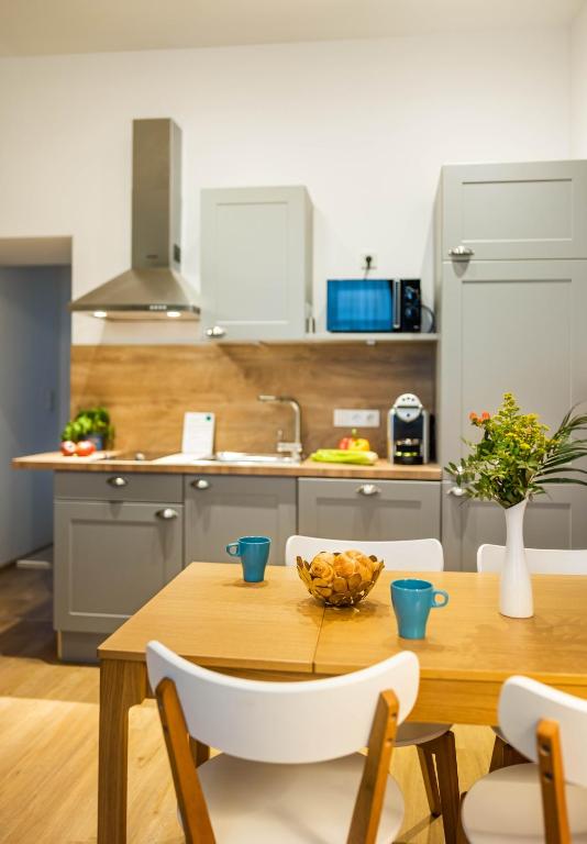 a kitchen with a wooden table with a bowl of fruit on it at Jimmy's Apartments Emerald in Vienna