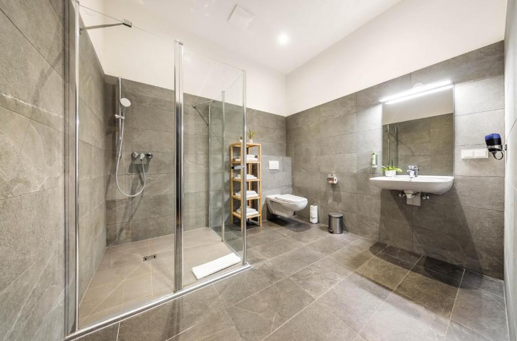 a bathroom with a shower and a sink and a toilet at Jimmy's Apartments Emerald in Vienna