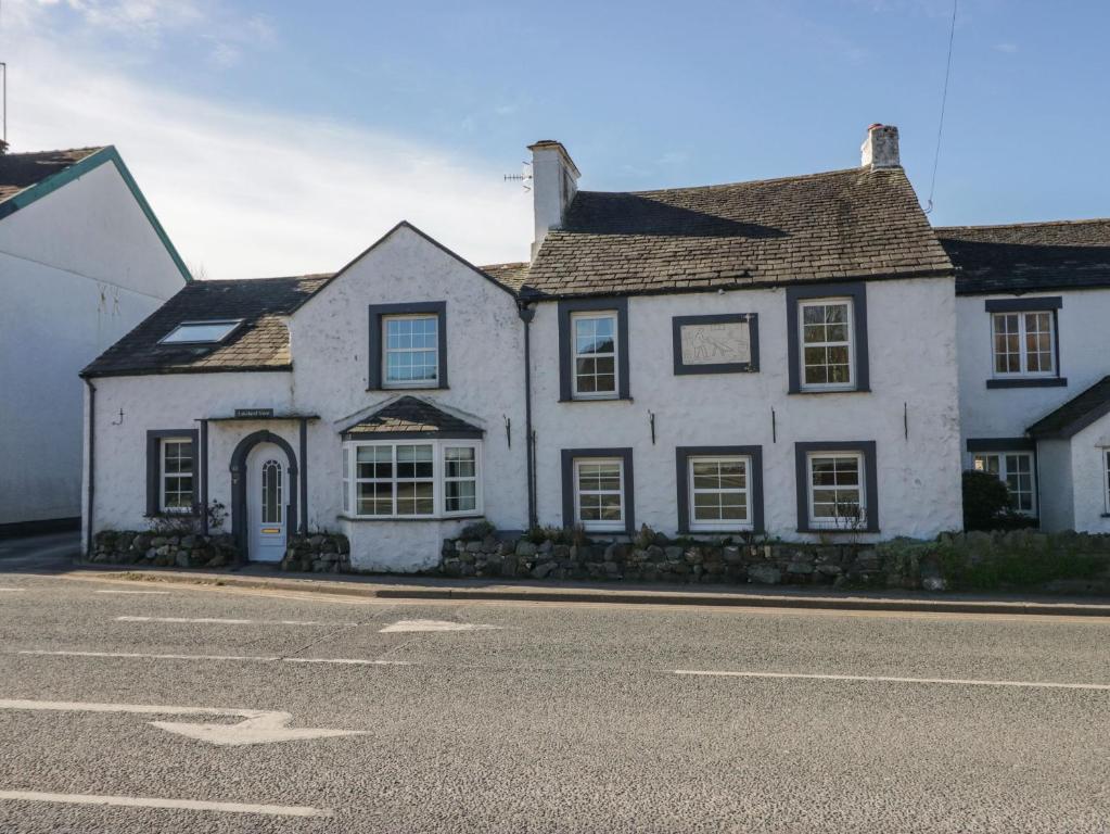 una casa blanca al lado de una calle en Lakeland View, en Keswick