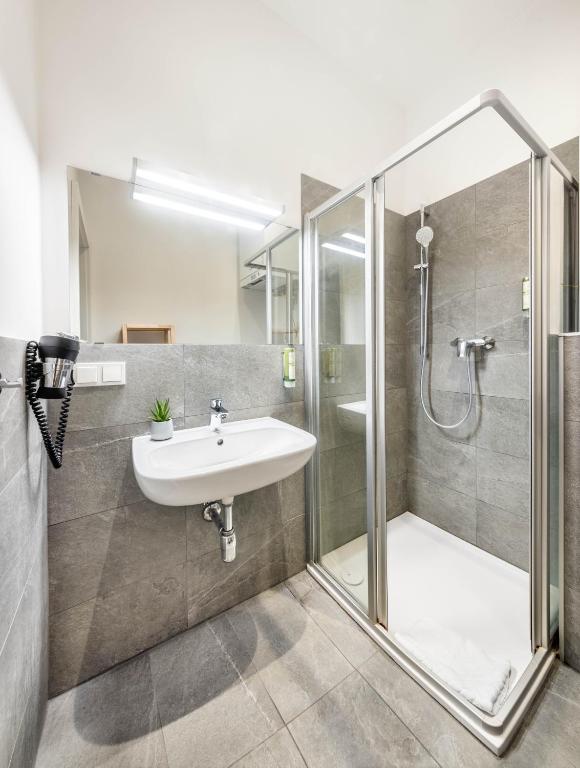 a bathroom with a sink and a shower at Jimmy's Apartments Emerald in Vienna