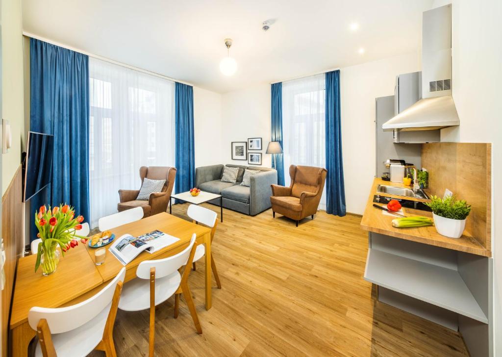 a living room with a table and chairs and a living room at Jimmy's Apartments Emerald in Vienna