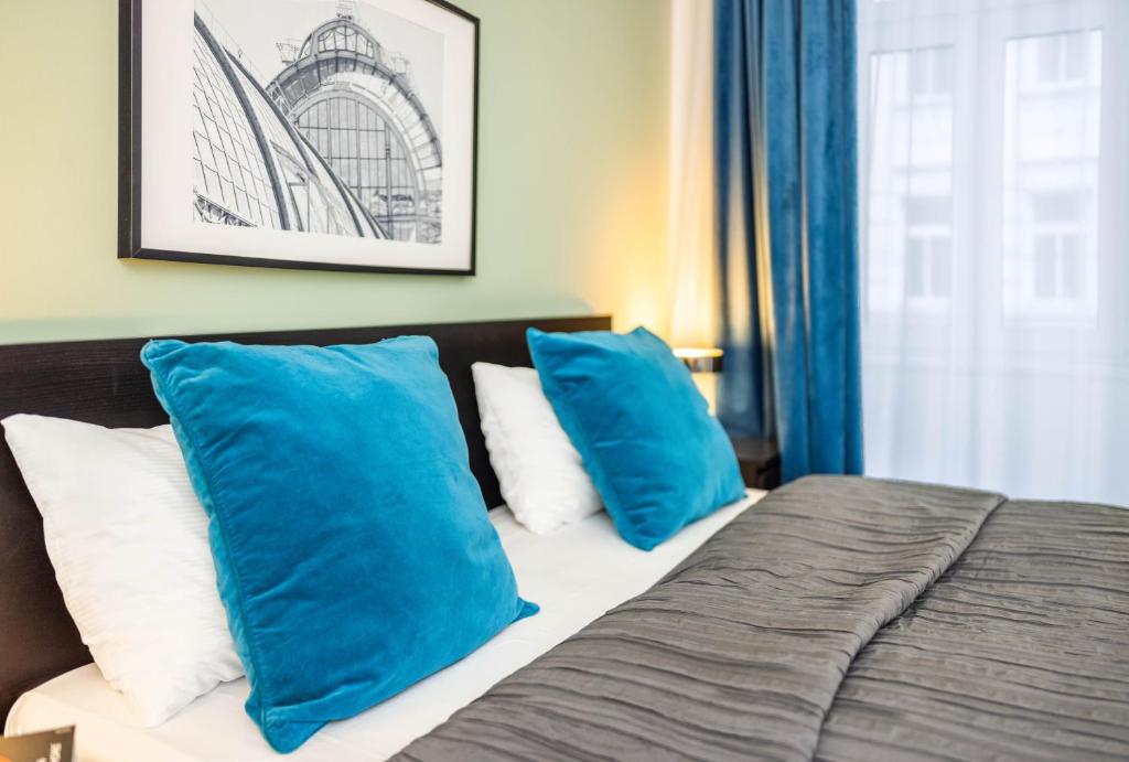 a bedroom with blue and white pillows on a bed at Jimmy's Apartments Emerald in Vienna