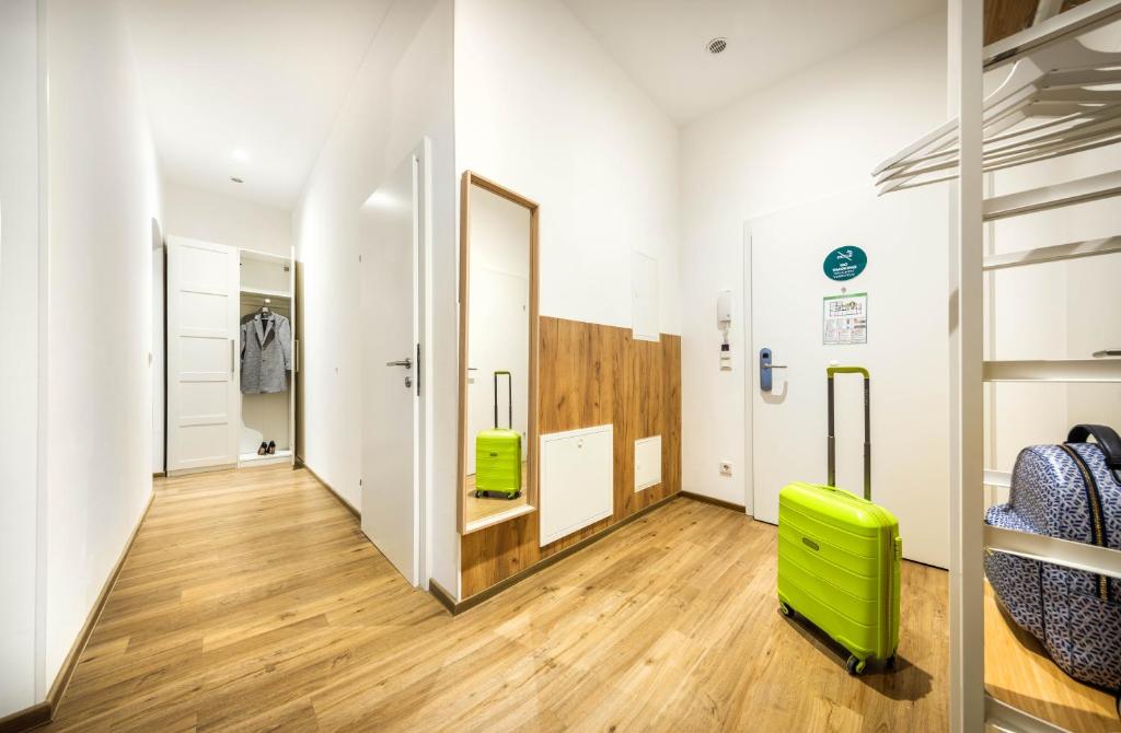 a room with a hallway with a green chair at Jimmy's Apartments Emerald in Vienna