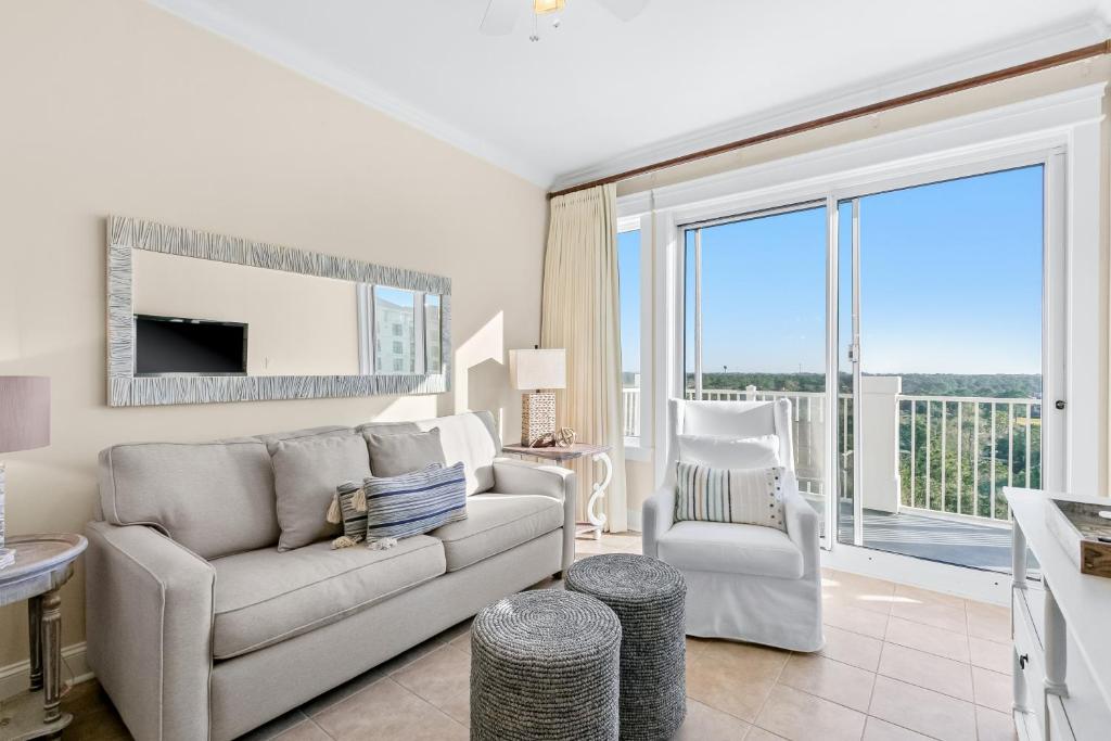 a living room with a couch and a chair andwindows at The Grand 2803 in Destin