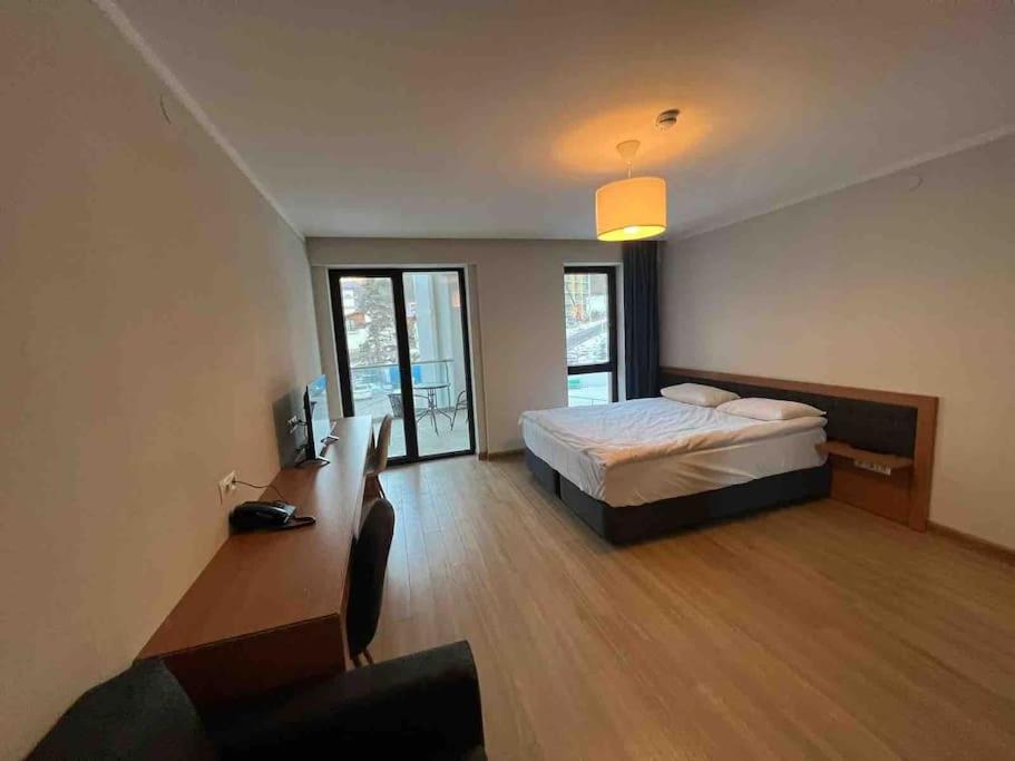 a bedroom with a bed and a desk with a television at Orbi Palace Bakuriani Apartment in Bakuriani