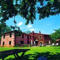 a large brick building with a picnic table in front of it at Molino De La Ferrería in Villacorta