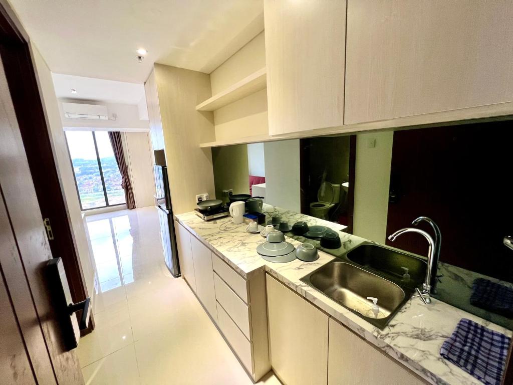 a kitchen with a sink and a counter top at ONE BEDROOM APARTMENT POLLUX MEISTERSTADT BATAM CENTRE in Batam Center