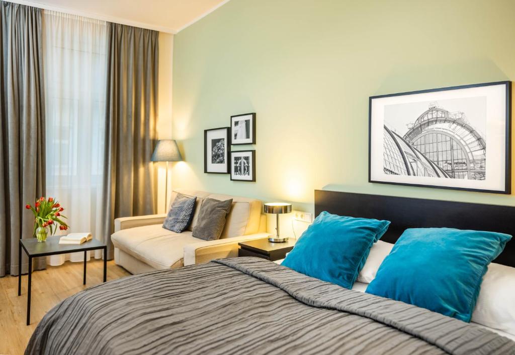 Habitación de hotel con cama y sofá en Jimmy's Apartments Emerald en Viena