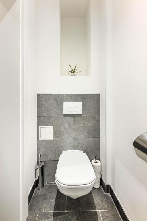 a bathroom with a white toilet in a room at Jimmy's Apartments Emerald in Vienna