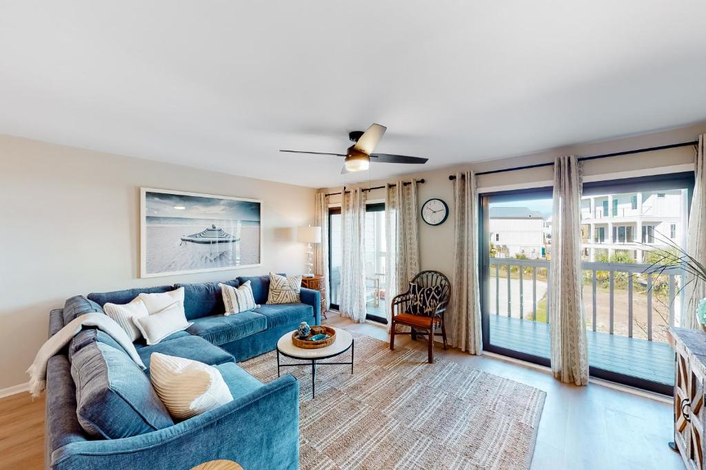 a living room with a blue couch and a window at Cotton Bayou B1 in Orange Beach