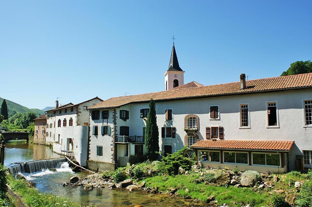 eine Gruppe von Gebäuden neben einem Fluss in der Unterkunft location 1 semaine minimum classé 3 étoiles in Aldudes