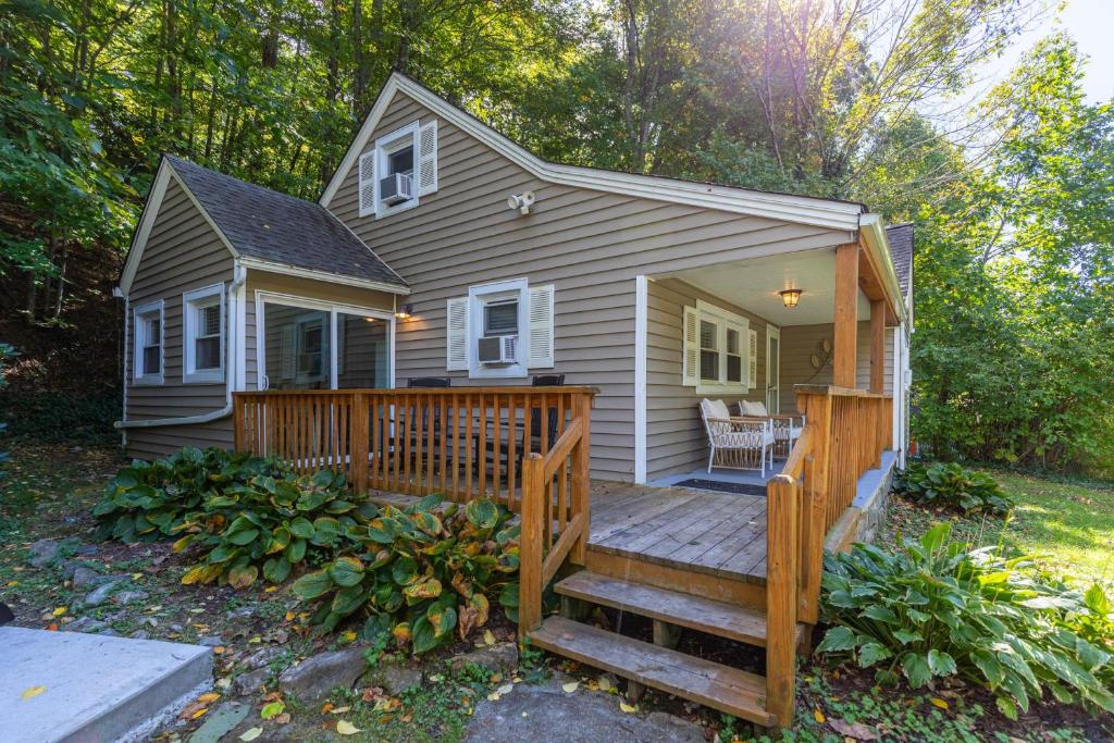 a small house with a wooden porch and a deck at Hot Toddy Cottage in Banner Elk