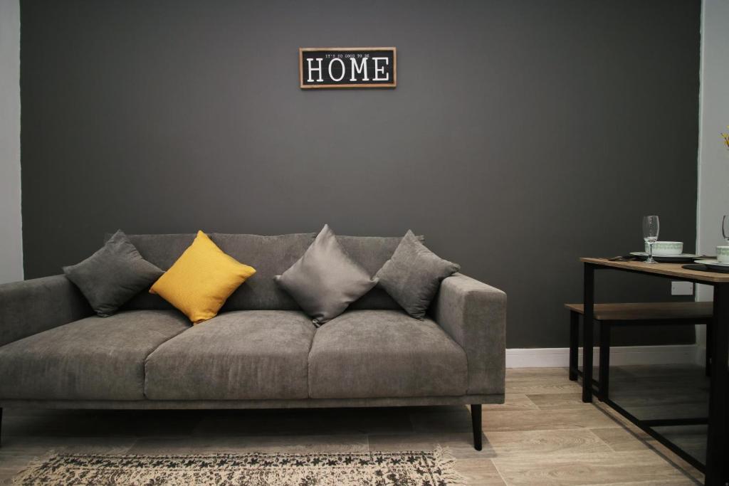 a living room with a gray couch with yellow pillows at skyline hanover 2 bedroom 203 in Swansea