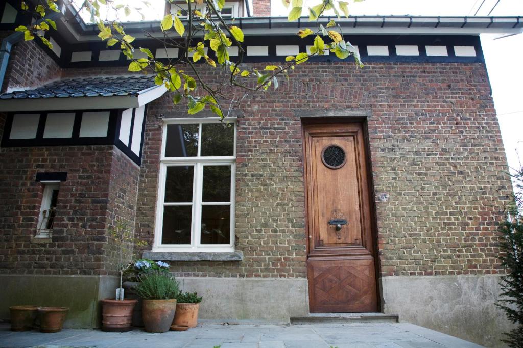 Una casa de ladrillo con una puerta de madera. en vakantiehuis ter poele, en Avelgem