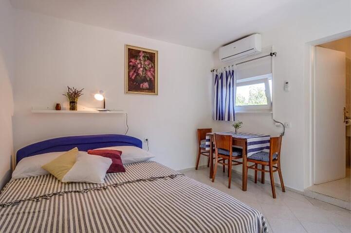 1 dormitorio con cama, mesa y comedor en Ivka 2, en Mali Lošinj
