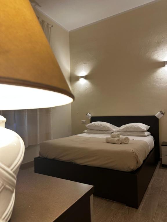 a bedroom with a bed with a lamp and pillows at Domo Achenza in Terralba
