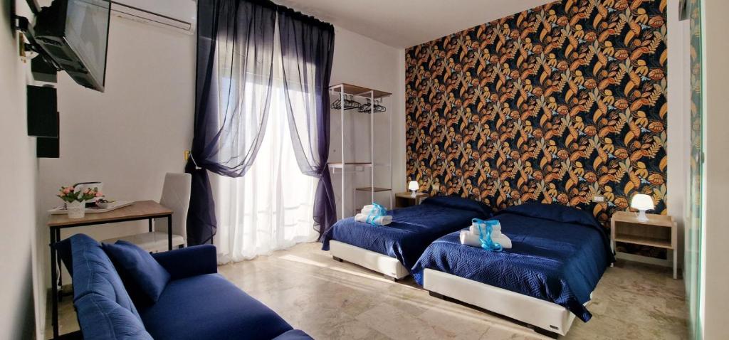 uma sala de estar com dois sofás azuis e uma grande janela em PANORAMICO em Catânia
