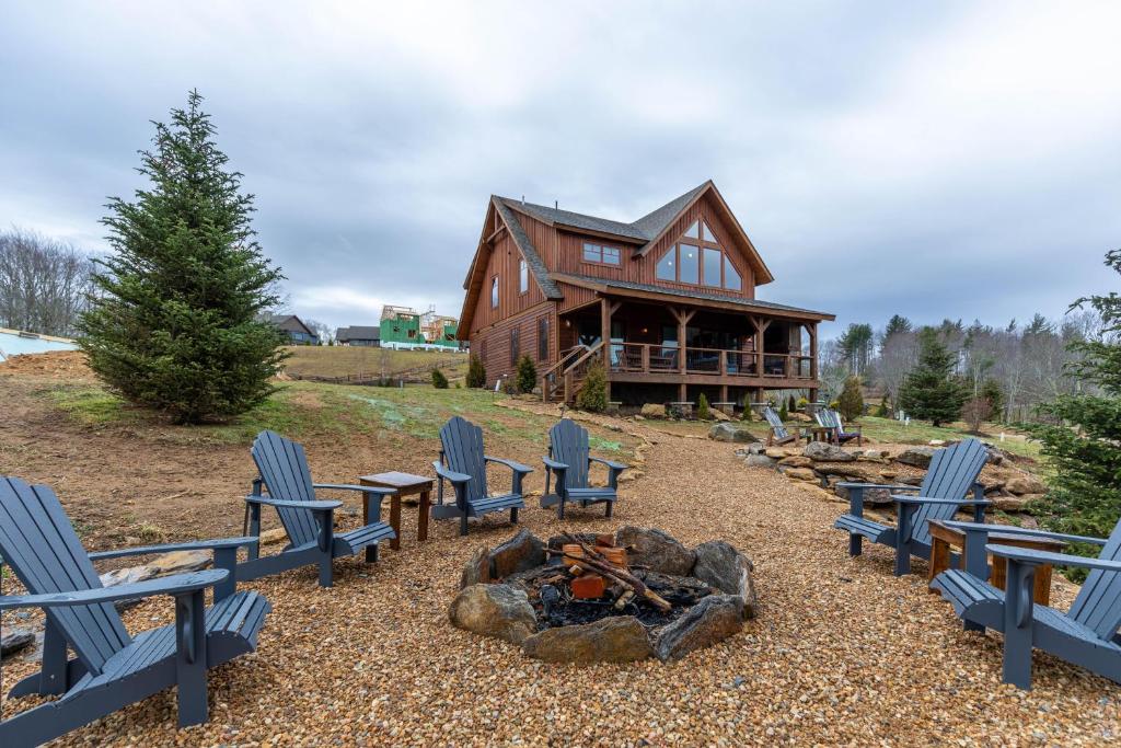 a log cabin with blue chairs and a fire pit at Neverending Story at Eagles Nest in Banner Elk