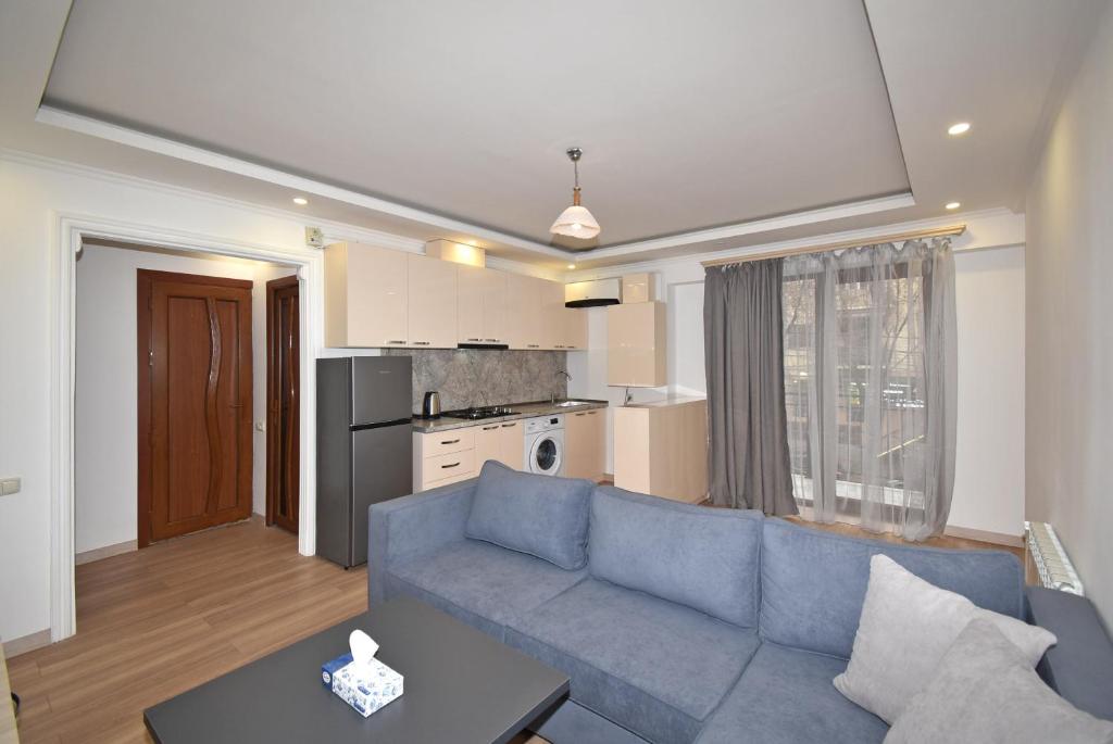 a living room with a blue couch and a kitchen at 19Tumanyan Excellent apartment in the centre of capital in Yerevan