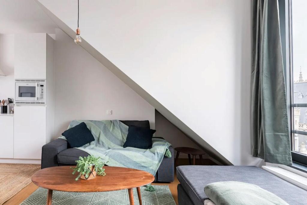ein Wohnzimmer mit einem Sofa und einem Tisch in der Unterkunft New apartment with big terrace and great views! in Löwen