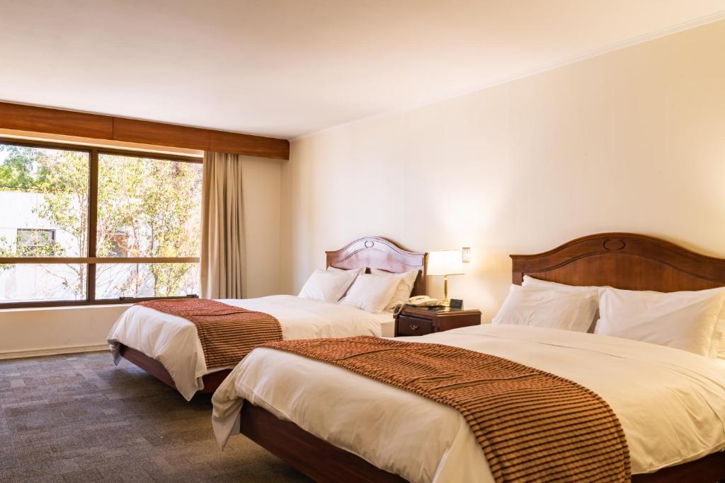 Postel nebo postele na pokoji v ubytování MR Hotel Providencia (ex Hotel Neruda)
