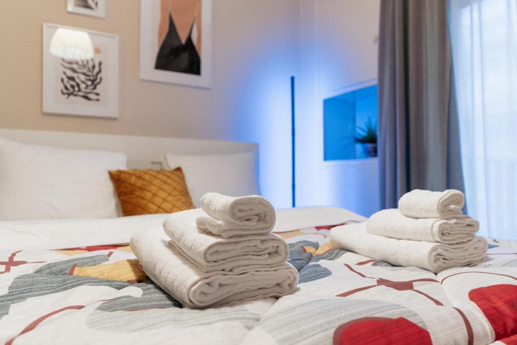 une pile de serviettes assises au-dessus d'un lit dans l'établissement Charming 85sqm Apartment with Panoramic City-Views, à Thessalonique