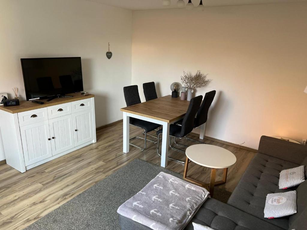 a living room with a table and chairs and a television at Insel Koje 1 in Fehmarn