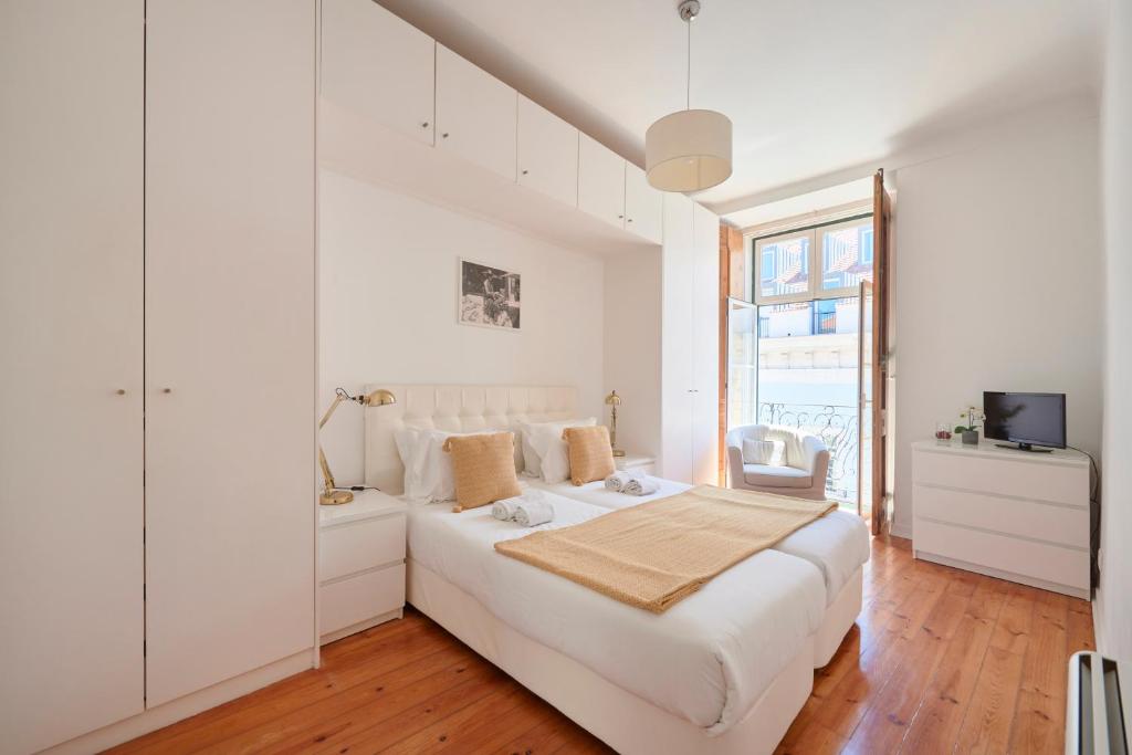 リスボンにあるCasa Portuguesa Chiadoの白いベッドルーム(大型ベッド1台、窓付)