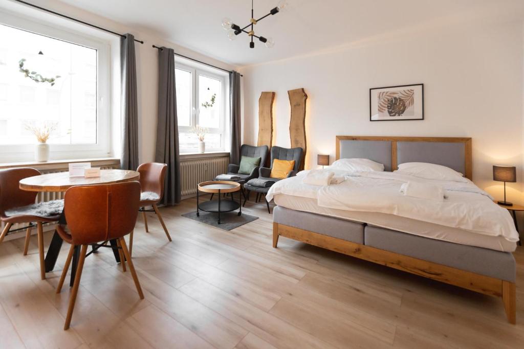 Schlafzimmer mit einem Bett, einem Tisch und Stühlen in der Unterkunft Koje Fünf I Apartment in Stadtmitte mit Hafenblick in Bremerhaven