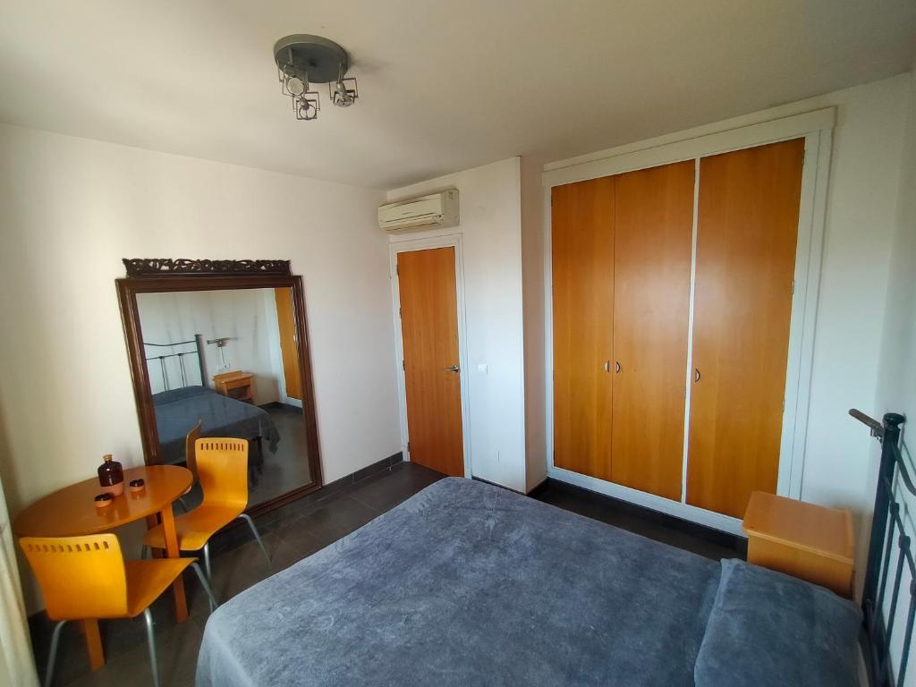 a bedroom with a bed and a table and chairs at Habitacion en casa particular con vista al mar in Cala del Moral