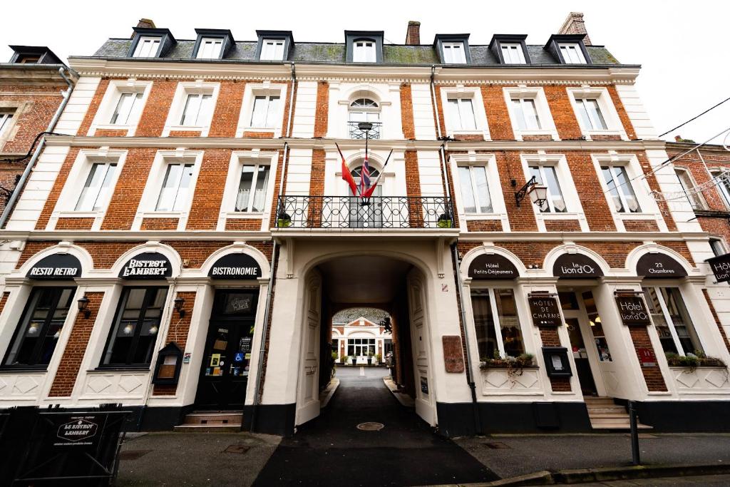 a large brick building with a balcony on a street at H&ocirc;tel Le Lion D'or in Bernay