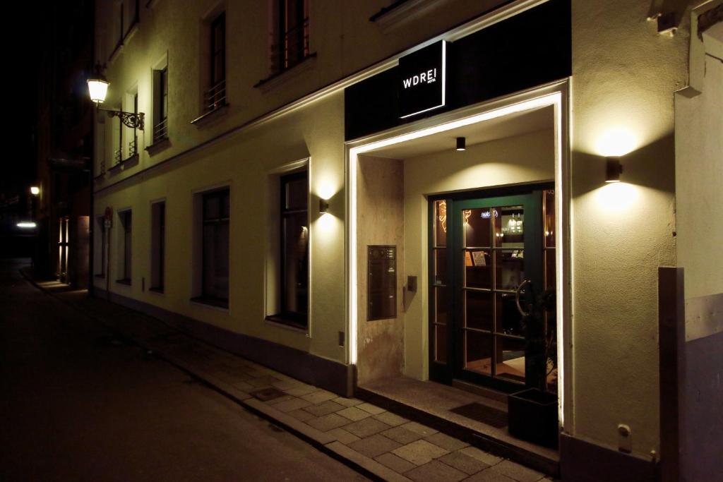 un magasin avec sa porte ouverte la nuit dans une rue dans l'établissement WDREI Hotel, à Munich