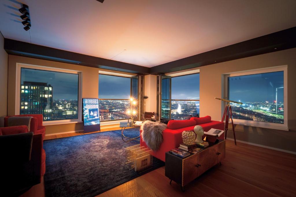 a living room with a red couch and large windows at Bohr Apartment Copenhagen in Copenhagen