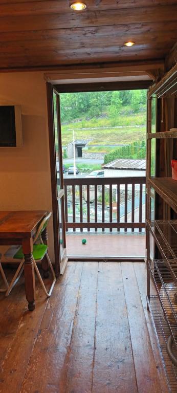 a room with a door open to a balcony with a table at SAM sulle piste in La Thuile