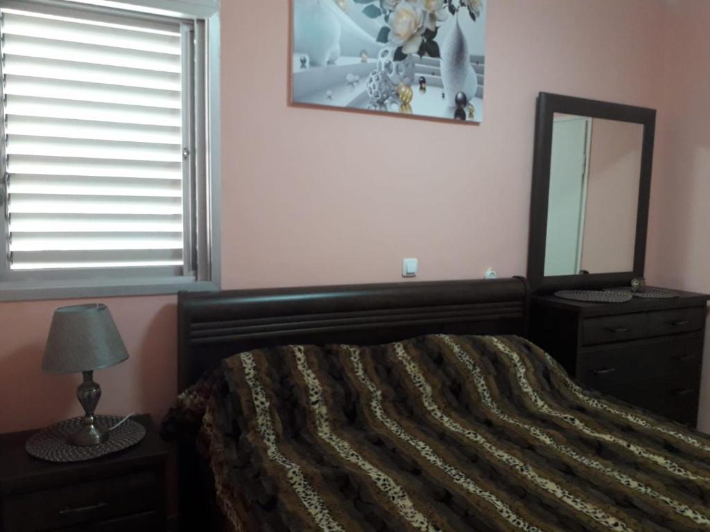 una camera con letto, cassettiera e specchio di Private room in the сomfortable apartment in Ashdod, 7 min walk to the beach a Ashdod