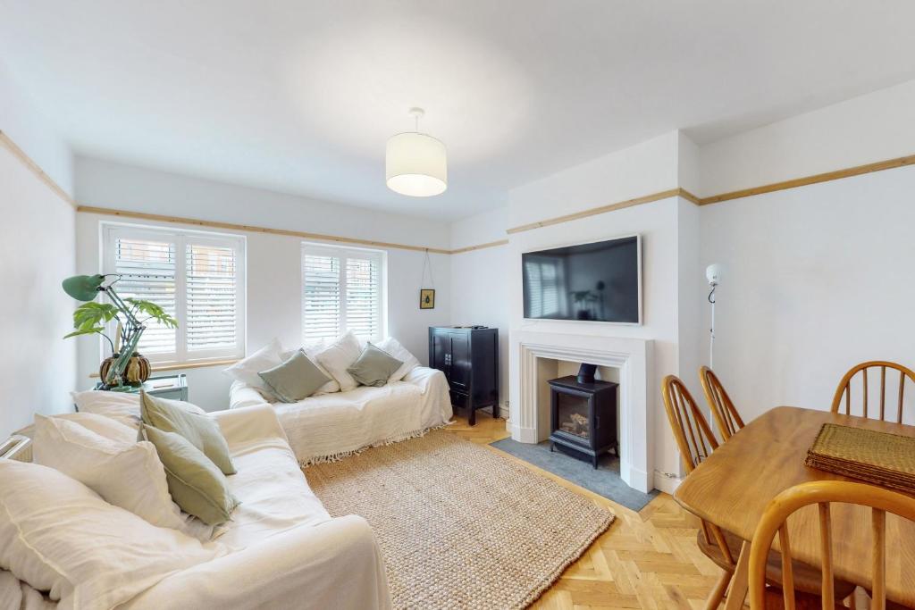 een woonkamer met een witte bank en een open haard bij Stunning 2 bed flat in Richmond in Kew