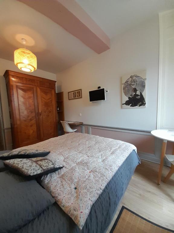 a bedroom with a bed and a tv on the wall at Chambre d'hôtes indépendante in Fougères