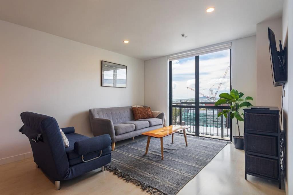 a living room with a couch and a table at Stunning Light-filled 2Bed w Car Park in Auckland