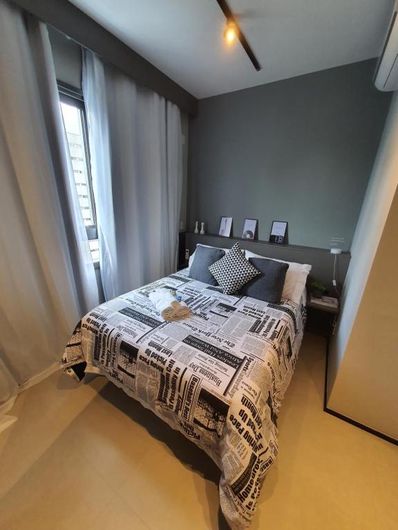 Un dormitorio con una cama con una manta. en Studio Perdizes Allianz, en São Paulo