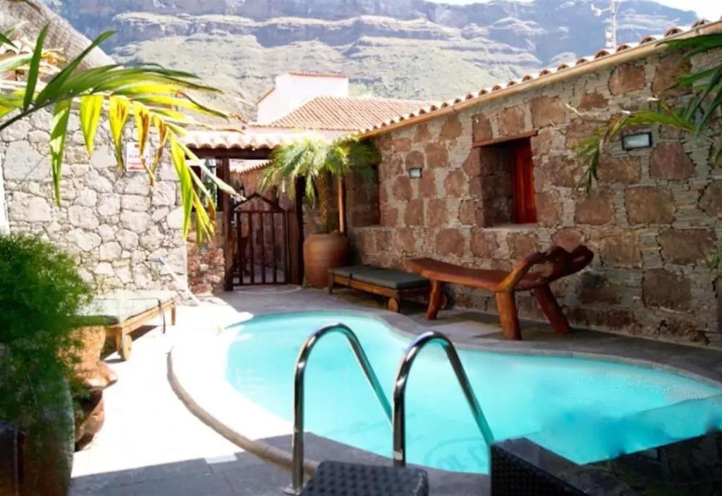 a house with a swimming pool with mountains in the background at Bentayga Sensation with Pool in Tejeda