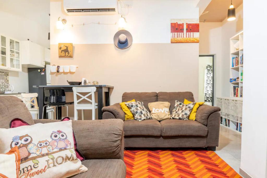 a living room with a couch and a kitchen at People LOVE this home! in Haifa