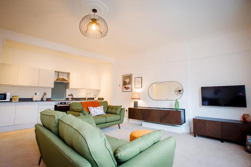 a living room with two couches and a kitchen at Victoria Apartment 2 in Torquay