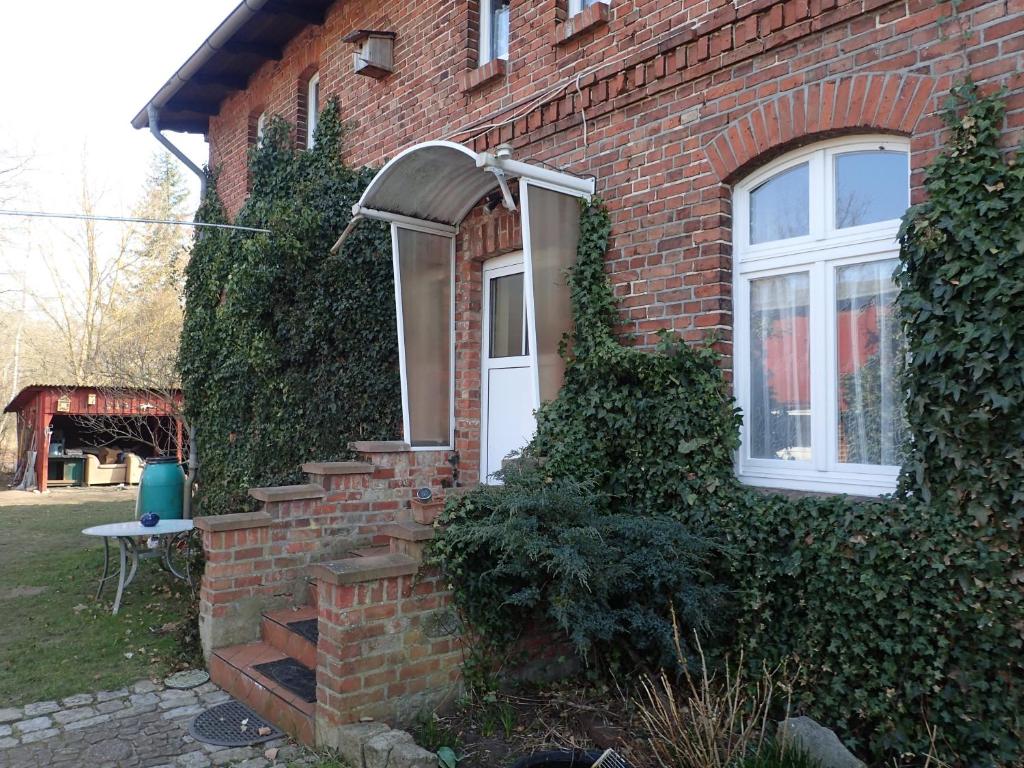 una casa de ladrillo con una puerta blanca y escaleras en Gemütliche Ferienwohnung in hirschreicher Umgebung, 