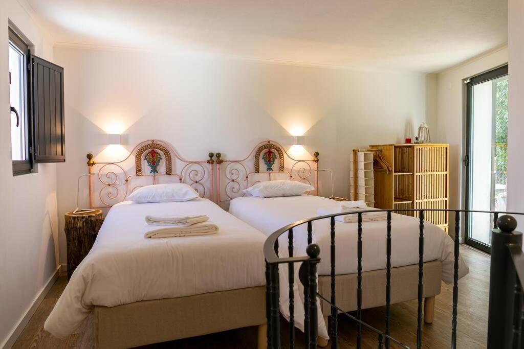 a bedroom with two beds and a window at Casinha - Lusitália Eden in Sintra
