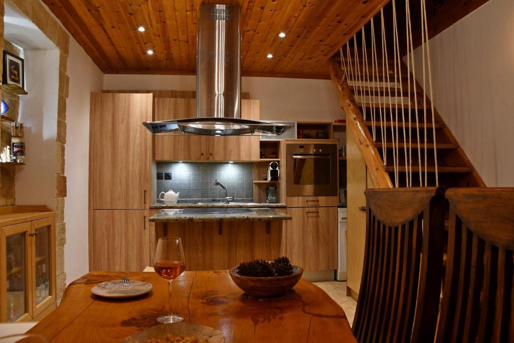 eine Küche mit einem Holztisch und einem Glas Wein in der Unterkunft The three story old town house in Rhodos (Stadt)